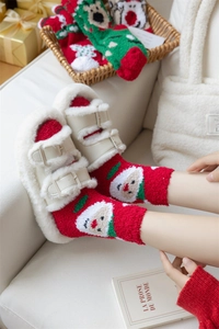 Detail of coral fleece Christmas socks featuring Santa Claus motifs and plush texture