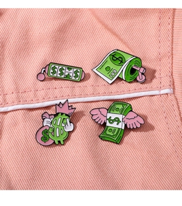 Detailed view of four cartoon dollar enamel pins on pink denim background texture