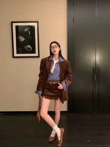 Detailed view of women retro corduroy blazer and skirt set with a classic brown leather belt