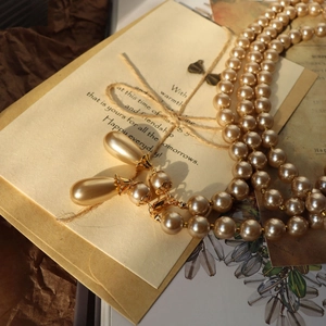 Detail of vintage Baroque multi-layer pearl necklace with champagne teardrop pendant