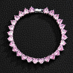 Macro view of pink heart-shaped stones tennis bracelet on black leather texture