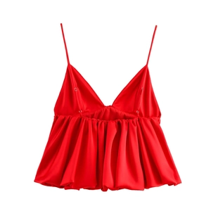 Détail d'un caraco en satin rouge à fines bretelles avec un ourlet plissé élégant