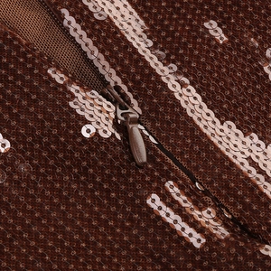 Detailed close-up of invisible zipper and shimmering bronze sequins on a slim evening dress