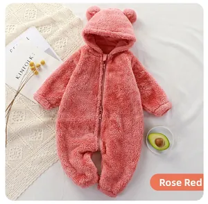 Détail d'une barboteuse bébé en peluche rose poudré avec oreilles d'ours et zip double