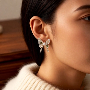 Macro shot of a vintage zircon bow earring on ear showing intricate craftsmanship