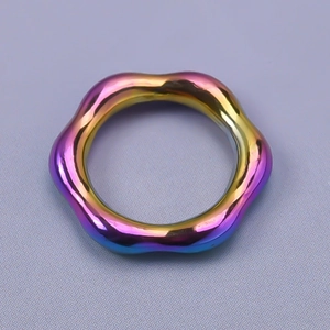 Macro shot of wavy rainbow iridescent metal ring with vibrant sculpture-like finish