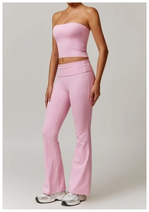 Détail d'un ensemble de yoga rose avec haut court ajusté et legging évasé taille haute