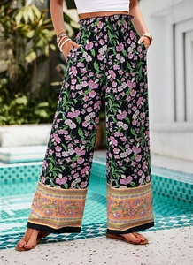 Détail d'un pantalon bohème large à imprimé fleuri rose avec une taille haute élastique