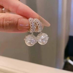 Detail of zircon lace metal hoop with hanging white pearl drop earrings for women
