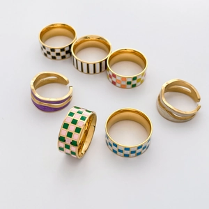 Flat lay of geometric enamel rings with checkered patterns and gold metallic finish