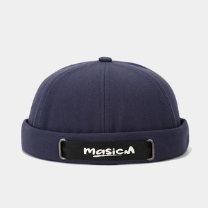 Détail du bonnet docker bleu marine avec sangle noire et broderie masicM blanche