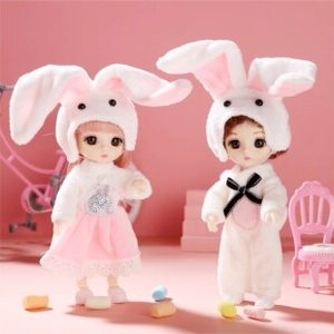 Detailed close-up of two adorable jointed dolls in soft bunny-themed plush outfits