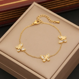 Bracelet doré élégant avec pendentifs papillons et nacre dans un coffret à bijoux chic