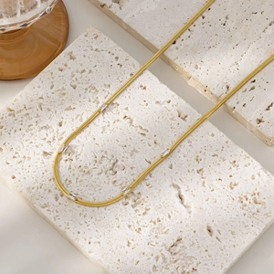Detail of 18K gold-plated snake chain necklace with sparkling square zircon accents