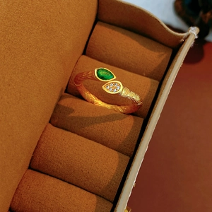 Détail de la bague plaquée or avec texture d'écorce et gemme verte en forme de poire