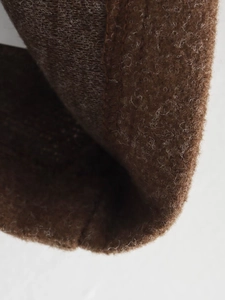 Close-up of thick brown wool blend fabric texture showing soft fuzzy material detail