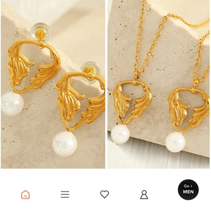 Detail of golden plant leaf jewelry set featuring white pearls on earrings and necklace
