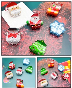 Detail of Christmas hair claws featuring snowman and glitter tree for holiday styling
