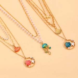Collana multistrato dorata con conchiglie, stelle marine, perle e ciondoli smaltati