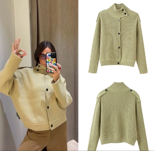 Detail of sage green chunky knit cardigan featuring high collar and shoulder epaulettes