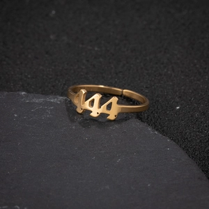 Macro shot of gold-tone adjustable ring featuring a hollowed 444 angel number design