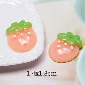 Makroaufnahme von 1,4x1,8cm Harz-Erdbeeranhängern in Rosa und Grün für DIY-Schmuck