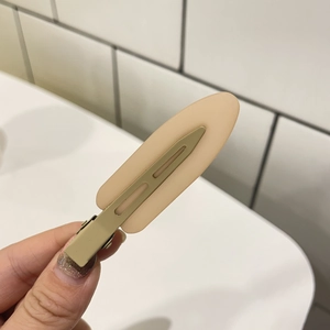 Close-up of minimalist beige matte duckbill hair clip for daily styling