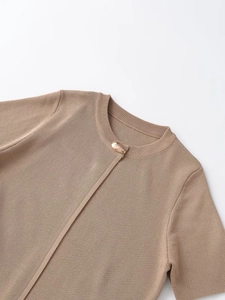 Detail of tan knit cardigan showing ribbed crew neck and polished gold oval metal button