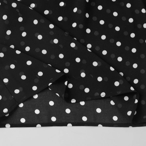 Détail macro du tissu mousseline à pois noirs et blancs avec finition d'ourlet
