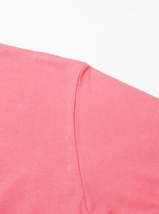 Detail of shoulder stitching and cotton knit texture on pink short sleeve t-shirt