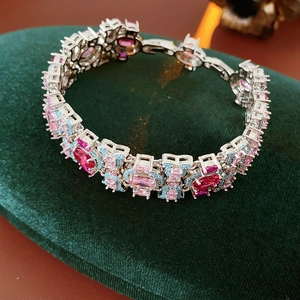 Détail du bracelet vintage en zircon avec pierres roses et bleues sur velours vert