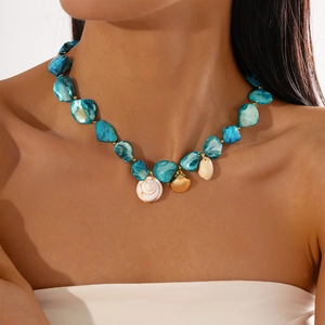 Detail of blue stone necklace with sea shell, starfish and golden scallop pendants