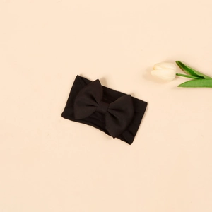 Detailed flat lay of a black elastic nylon baby headband with a large decorative bow