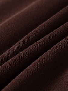 Close-up of high-density knit fabric in deep chocolate showing detailed texture