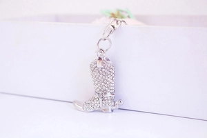Macro view of crystal rhinestone cowboy boot keychain with polished silver metal finish