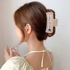 Beige square claw clip with YEE HAW lettering and spade design shown on model hair