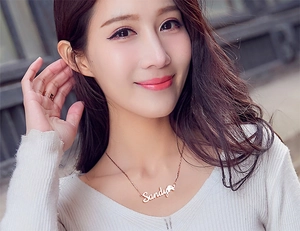 Gros plan du collier prénom Sandy personnalisé en or rose avec détail cœur sur un mannequin