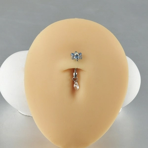 Titanium belly button ring with blue zircon flower and teardrop pendant on model