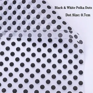 Close-up of translucent gold polka dot floral wrapping paper with 0.7cm black dots