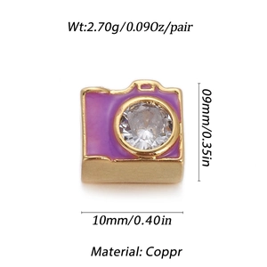 Dettaglio macro di ciondolo a fotocamera in rame placcato oro con smalto viola e zircone