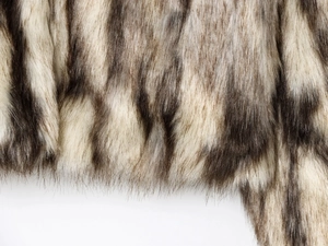 Dettaglio ravvicinato della pelliccia sintetica bianca e marrone per un cappotto elegante