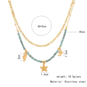 Macro detail of double-layer stainless steel necklace with blue beads and sea horse charms