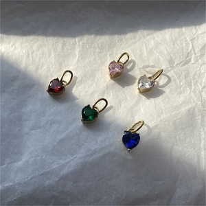 Detailed view of heart-shaped gold pendants set with colorful zircon stones