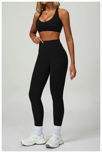 Dettaglio dei leggings sportivi neri a vita alta e del reggiseno con trama senza cuciture