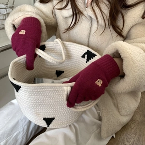 Detail of red bear embroidery on knitted gloves with warm winter knit texture