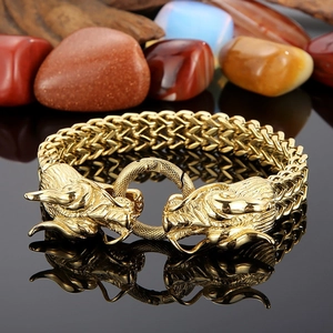 Détail des fermoirs à tête de dragon sur un bracelet en maille tressée plaqué or 18K