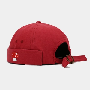 Detail of red dock worker cap with mushroom embroidery and adjustable metal buckle