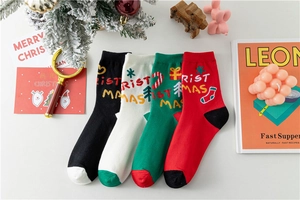 Vue à plat de quatre paires de chaussettes de Noël en coton avec broderies festives