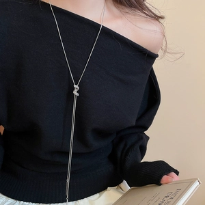 Detail of silver adjustable spiral necklace with zirconia tassels on black sweater