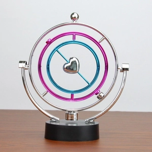 Kinetic desk toy with pink and blue rotating rings and silver heart on black base